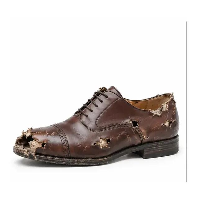 Shoe damaged by rat or dog bite before professional repair